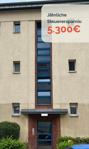 Mehrfamilienhaus in berlin mit heller Fassade, blauem Eingangsbereich.