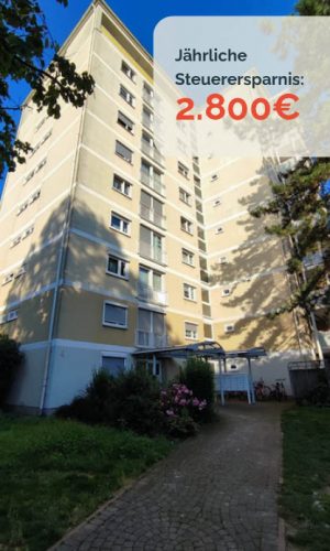 Mehrstöckiges Wohngebäude mit beige-gelber Fassade, Gartenweg.